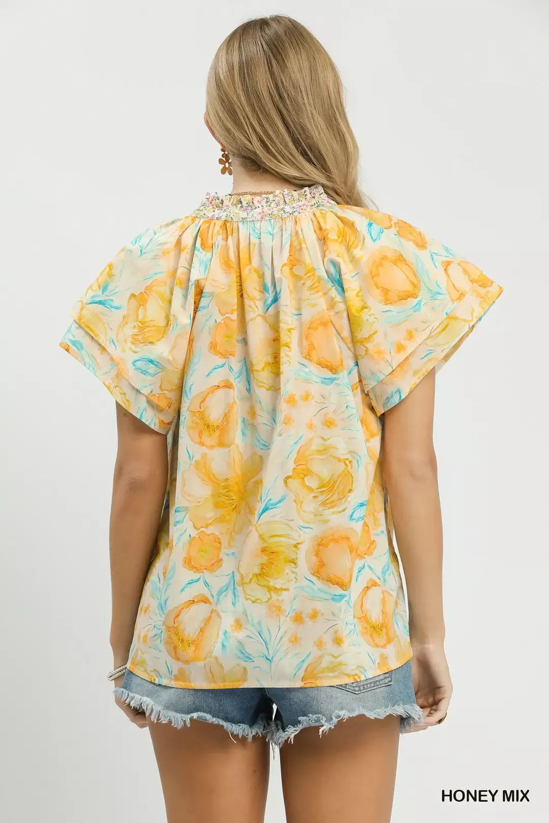 Umgee floral print blouse with crochet lace trim, featuring a mix of colorful floral patterns and delicate lace details.