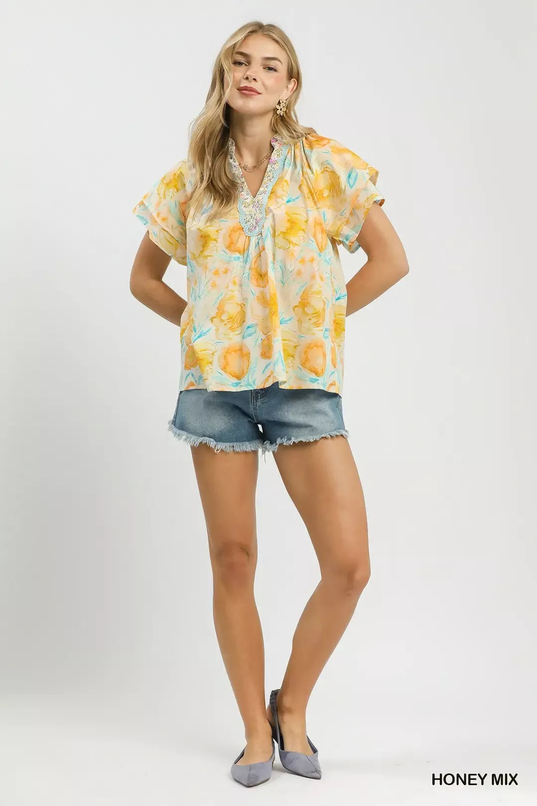 Umgee floral print blouse with crochet lace trim, featuring a mix of vibrant flowers and delicate lace details.