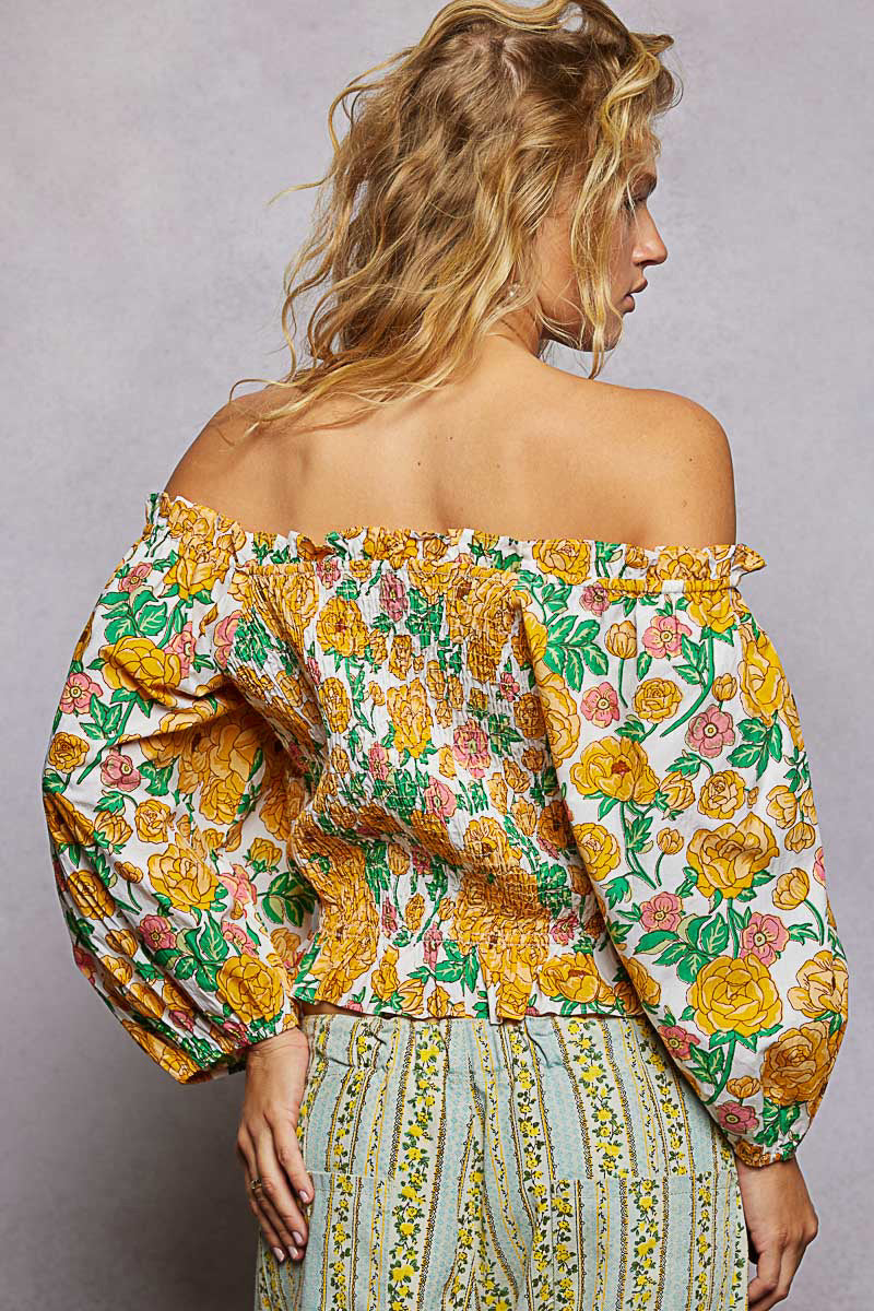 Trendsi floral print off-shoulder smocked blouse with long sleeves and ruffled neckline on a model.