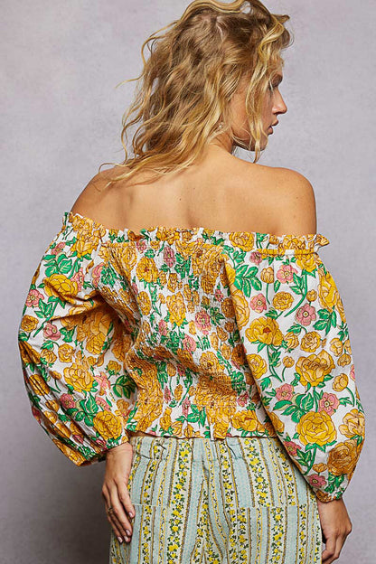 Trendsi floral print off-shoulder smocked blouse with long sleeves and ruffled neckline on a model.