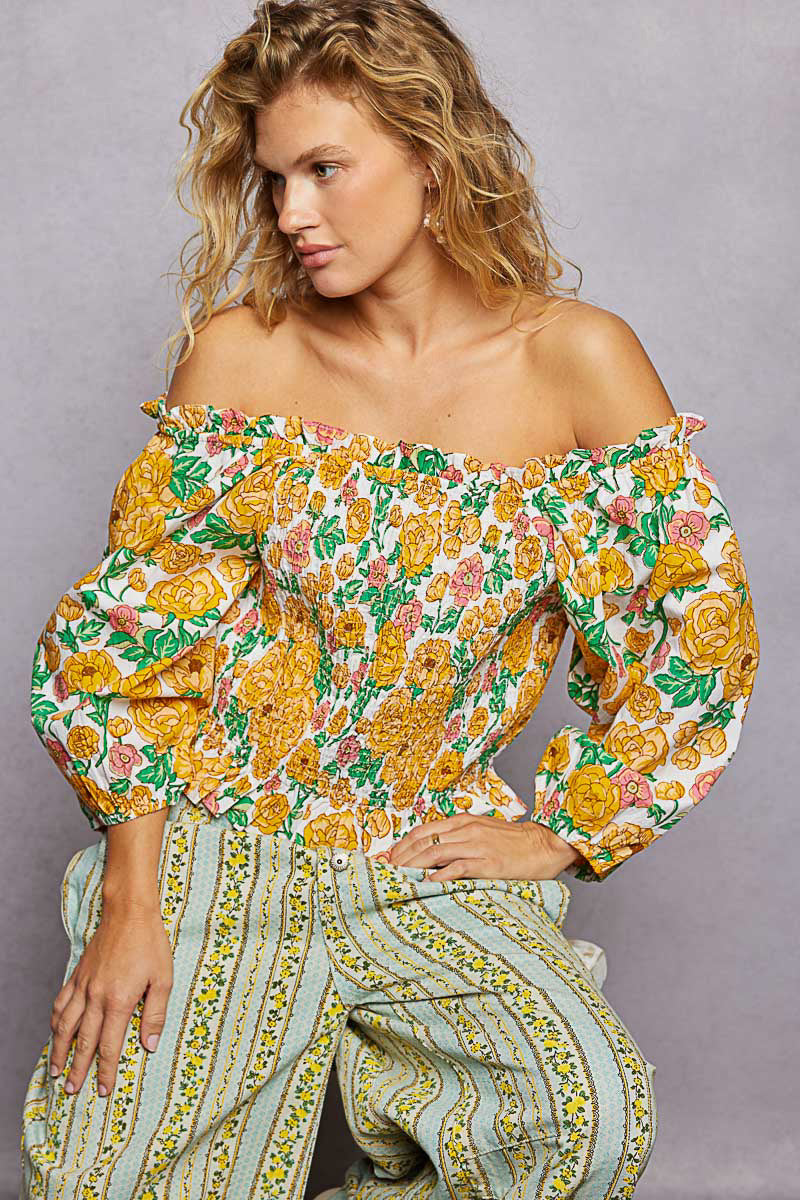 Trendsi floral print off-shoulder smocked blouse with long sleeves and ruffled neckline, featuring a colorful, feminine design.