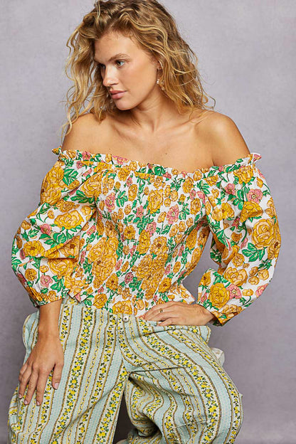 Trendsi floral print off-shoulder smocked blouse with long sleeves and ruffled neckline, featuring a colorful, feminine design.