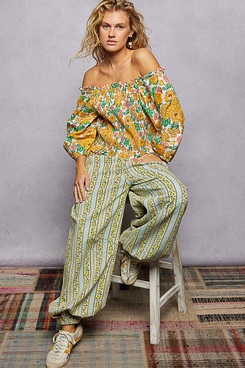 Trendsi floral print off-shoulder smocked blouse with long sleeves and ruffle detailing, featuring a colorful multicolor floral pattern.
