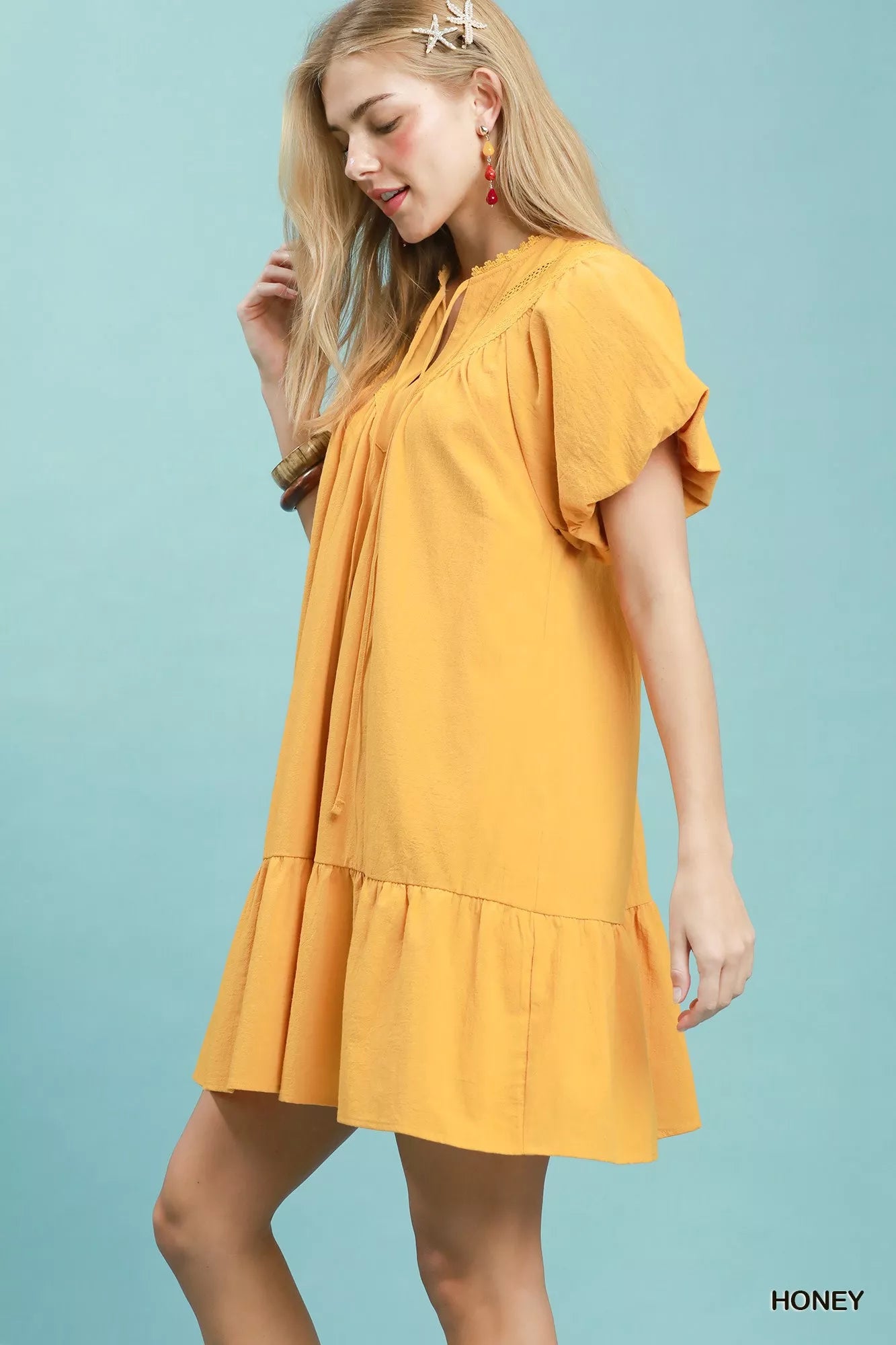Umgee mini dress with flutter sleeves, tassel tie detail, and ruffle hem in a stylish, casual design.