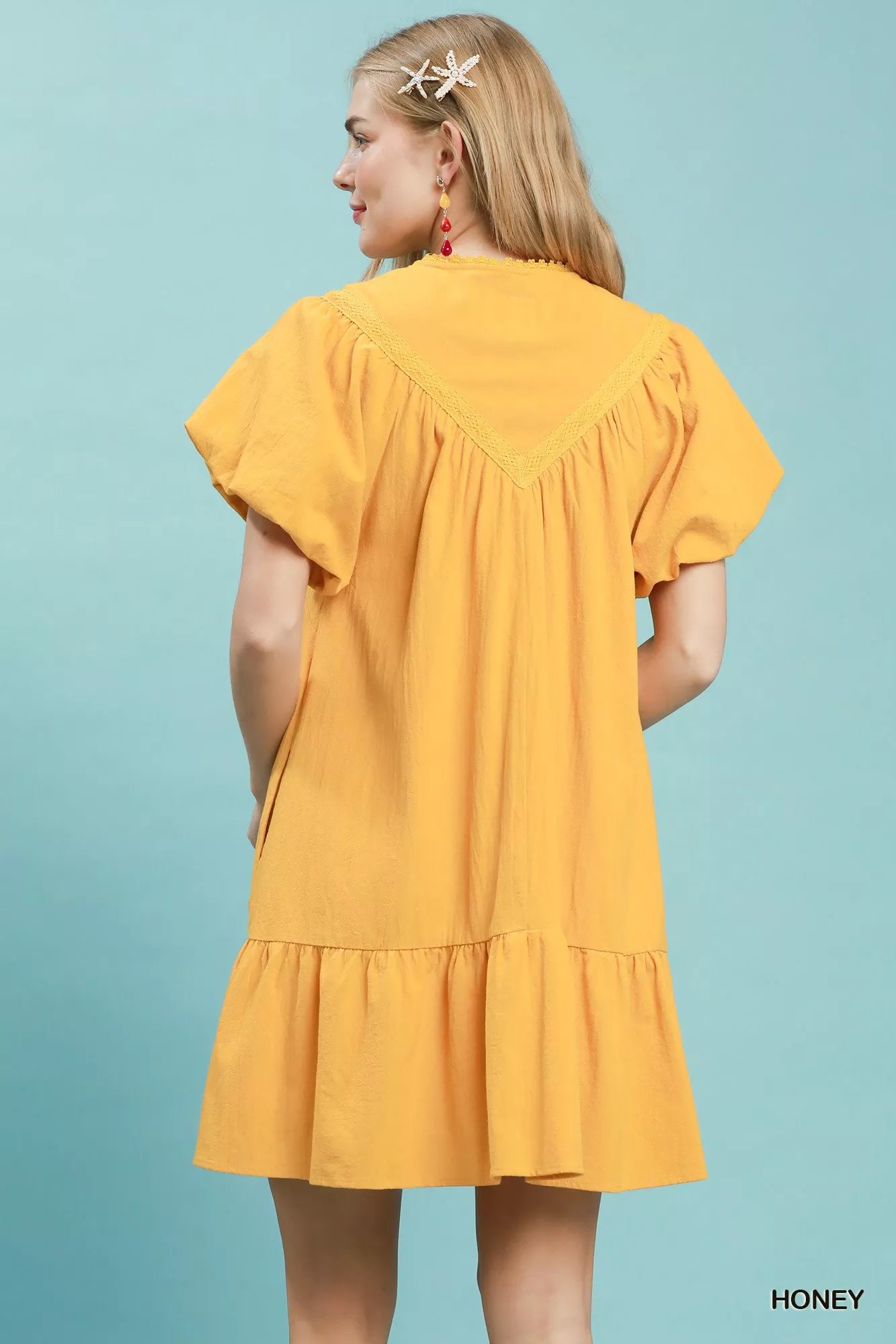 Umgee mini dress with flutter sleeves, tassel tie detail, and ruffle hem, featuring a stylish and casual summer look.