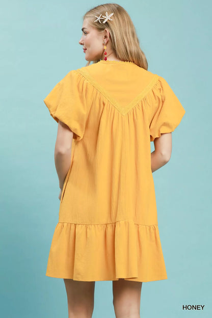 Umgee mini dress with flutter sleeves, tassel tie detail, and ruffle hem, featuring a stylish and casual summer look.