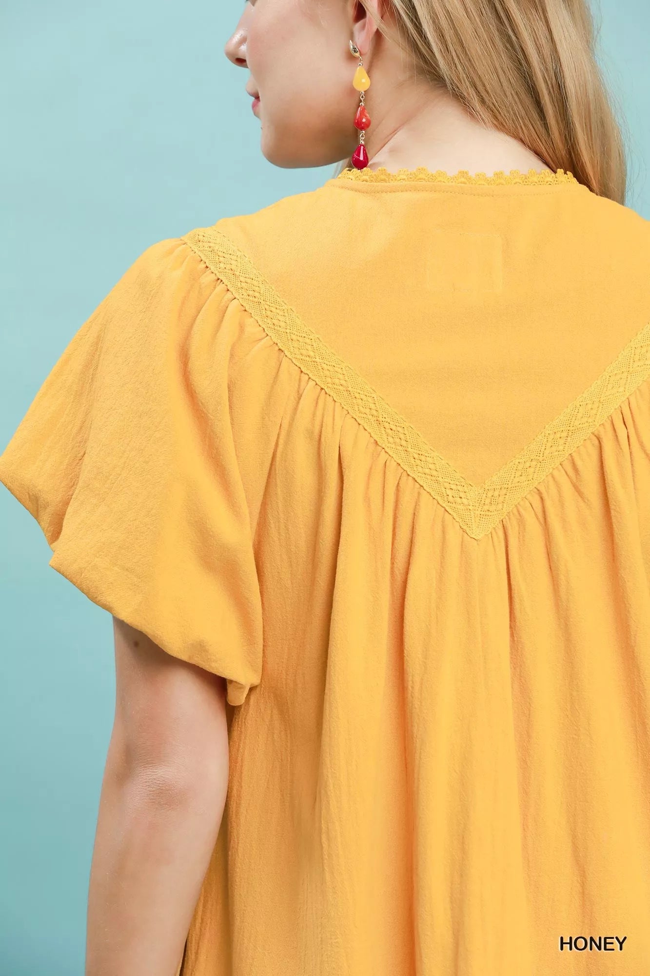 Umgee mini dress by Trendsi featuring flutter sleeves, tassel tie detail, and a ruffle hem in a stylish, casual design.