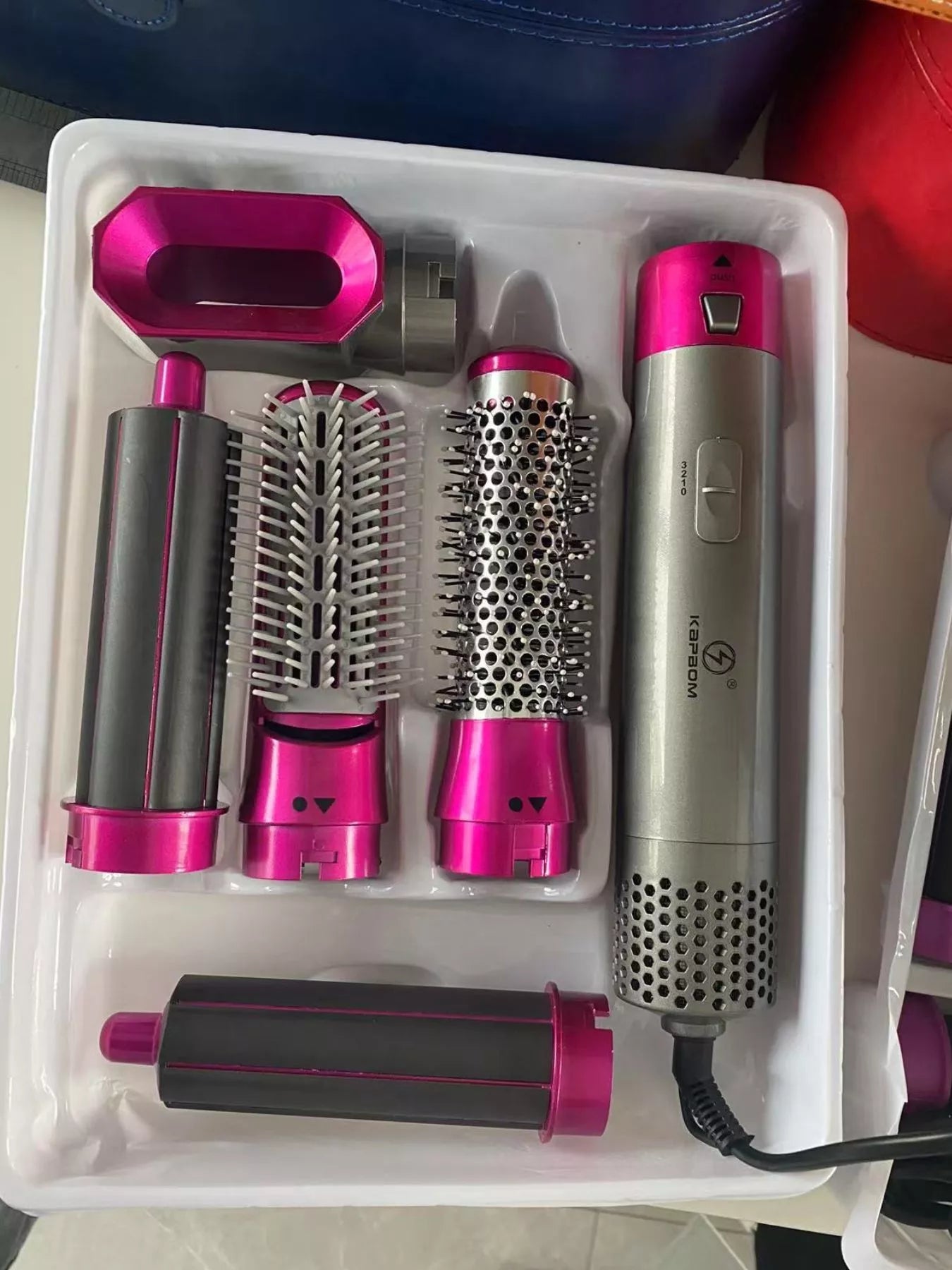 Hot pink Trendsi interchangeable curling iron wand set with European plug, featuring multiple barrel sizes for versatile curls.