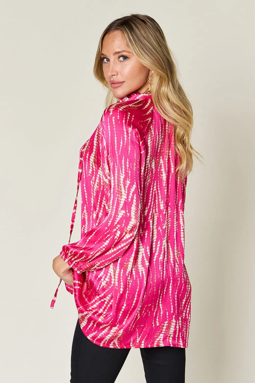 Hot pink Trendsi Double Take full-size printed button-up long sleeve shirt hanging on a rack.