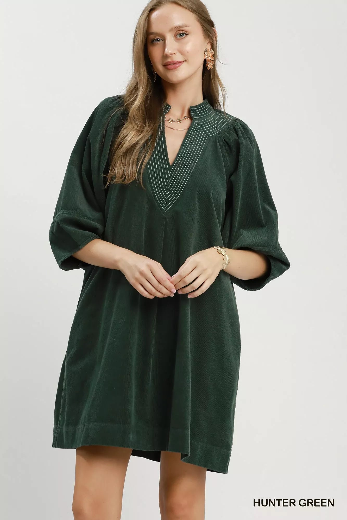 Hunter green Umgee corduroy V-neck puff sleeve shift dress with front pockets, styled for casual and stylish wear.
