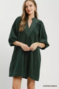 Hunter green Umgee corduroy V-neck puff sleeve shift dress with front pockets, styled for casual and stylish wear.