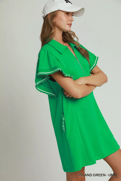 Island green Umgee mini dress with ruffle rib band, butterfly sleeves, half-zip front, and pockets, styled by Trendsi.