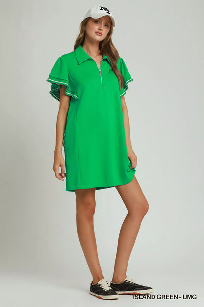 Island green Umgee mini dress with ruffle rib band, half-zip, butterfly sleeves, and pockets, styled on a model.