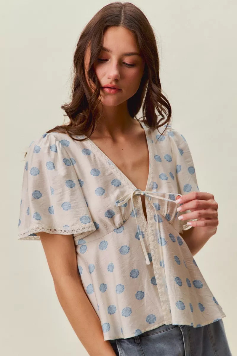 Ivory and blue SO ME shell print tie-front blouse with flutter sleeves, trendy top by Trendsi, perfect for casual or stylish wear.