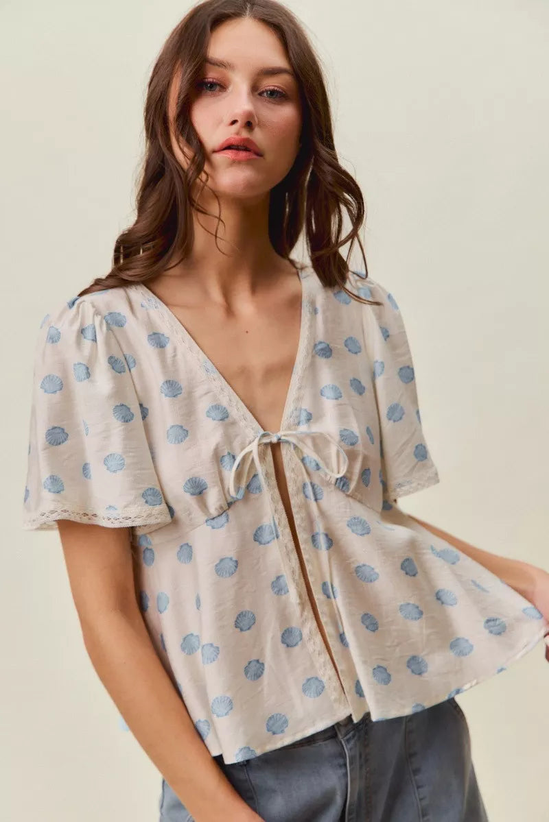 Ivory and blue SO ME shell print blouse with tie-front and flutter sleeves, Trendsi women's casual top.