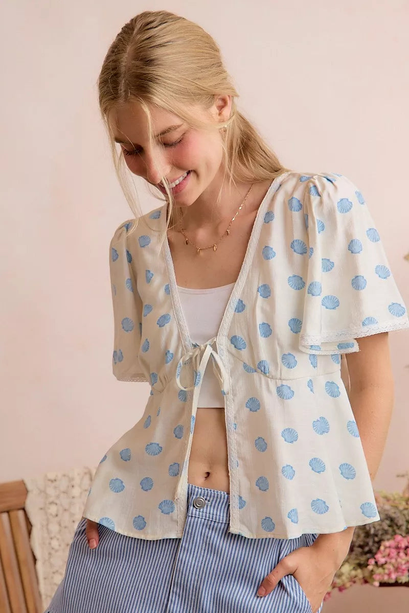 Ivory and blue SO ME shell print tie-front blouse with flutter sleeves, trendy top by Trendsi, perfect for casual or summer wear.