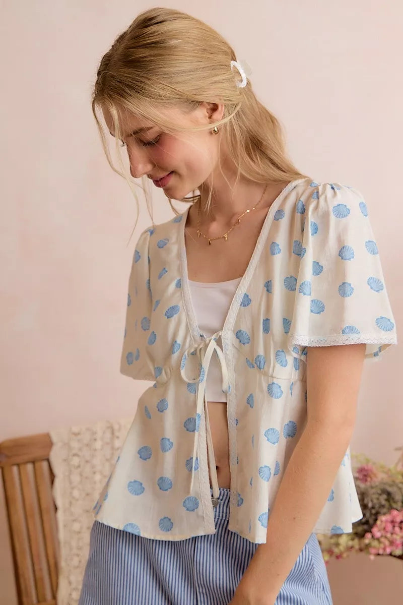Ivory and blue SO ME shell print blouse top with tie front and flutter sleeves, stylish and lightweight for casual wear.