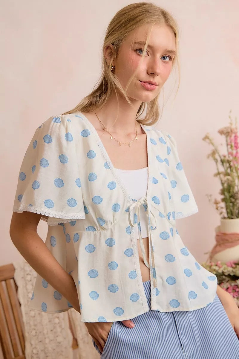 Ivory and blue shell print tie-front flutter sleeves blouse top by Trendsi, featuring lightweight fabric and stylish design.