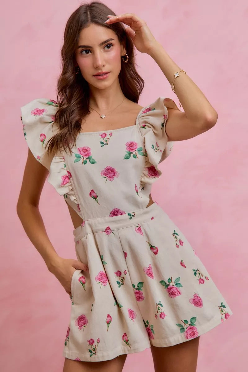 Ivory pink floral print denim romper with cut-out waist and ruffled details, trendy and stylish by Trendsi.