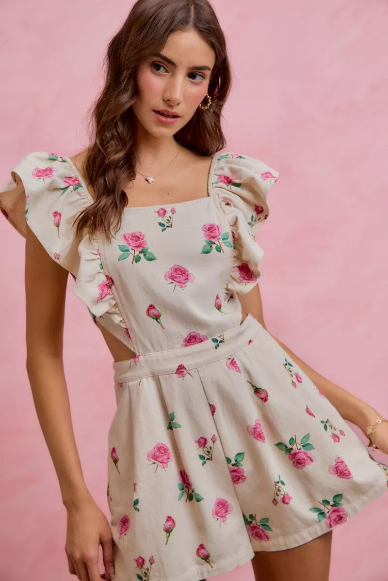Ivory and pink floral print denim romper with cut-out waist and ruffled details by Trendsi, styled on a model.