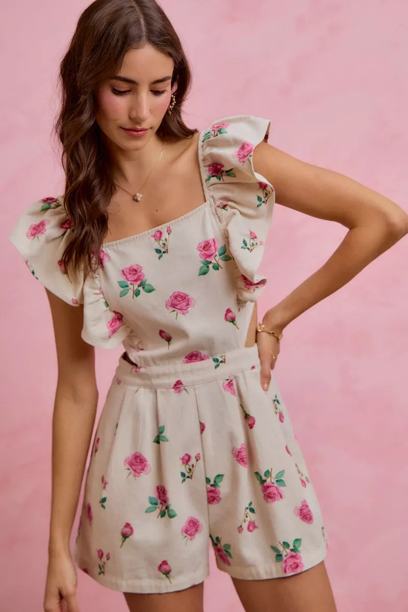 Ivory pink floral print denim romper with cut-out waist and ruffled details, designed by Trendsi.