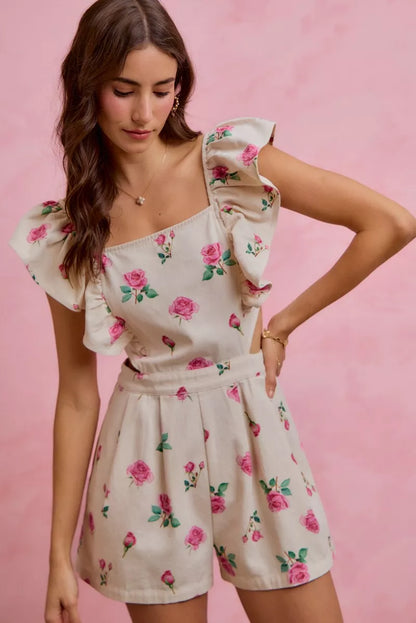 Ivory pink floral print denim romper with cut-out waist and ruffled details, designed by Trendsi.