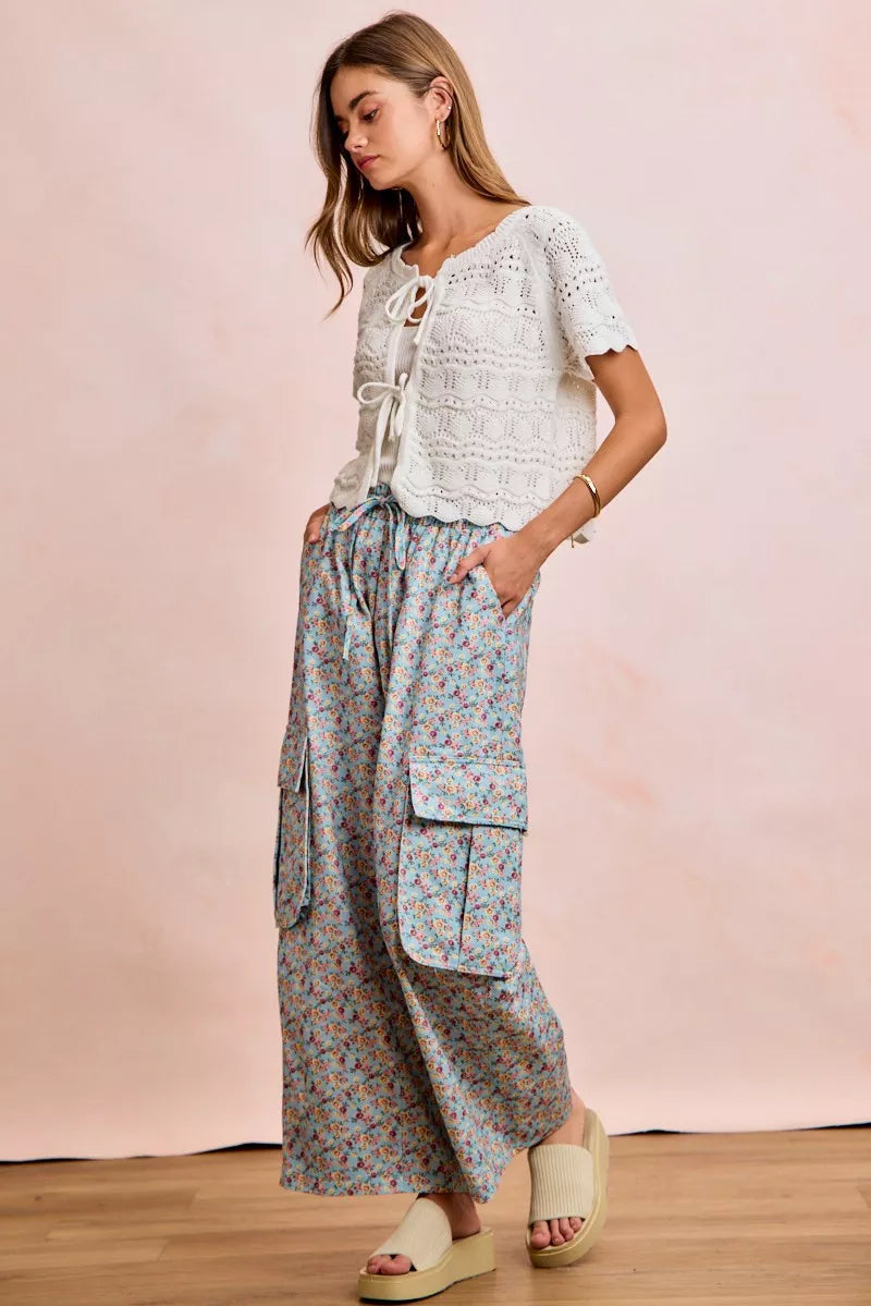 Ivory pointelle knit top with front bow tie detail by Trendsi, showcasing a stylish and feminine design.