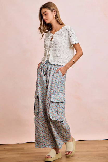 Ivory pointelle knit top with front bow tie detail by Trendsi, showcasing a stylish and feminine design.