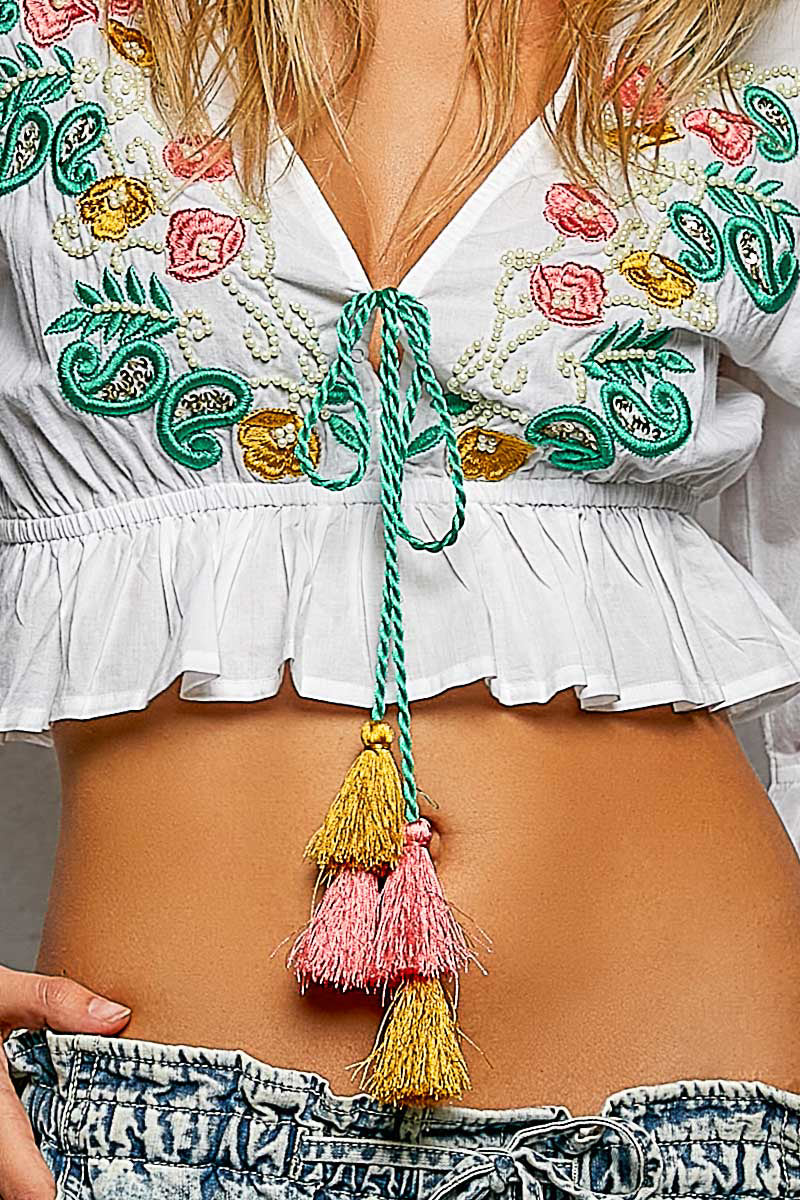 Ivory floral embroidered cropped blouse by Trendsi featuring intricate embroidery and a stylish, fitted design.
