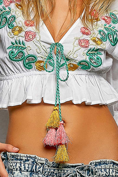 Ivory floral embroidered cropped blouse by Trendsi featuring intricate embroidery and a stylish, fitted design.