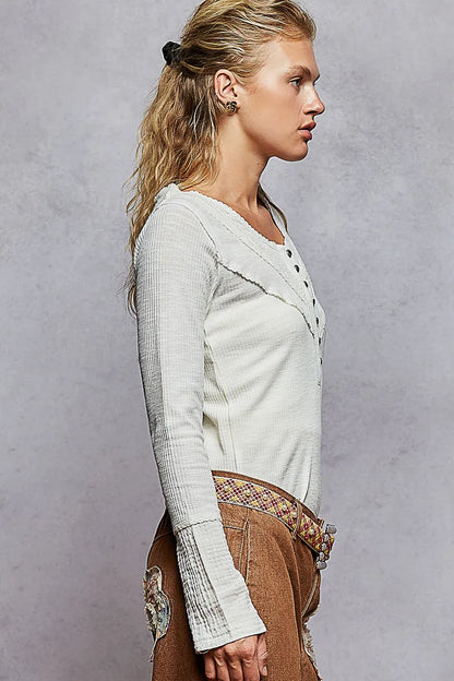 Ivory ribbed knit top with half button closure and lace detail, by Trendsi, showcasing a close-up of the textured fabric and button design.