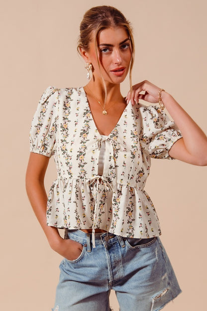 Ivory floral print tie-front blouse by Trendsi featuring a shirred hem and long sleeves, perfect for casual or dressy looks.