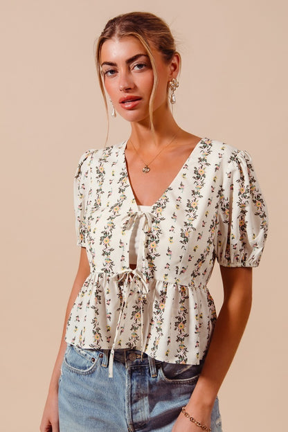 Ivory floral print tie front blouse with shirred hem by Trendsi, featuring a stylish and feminine design.