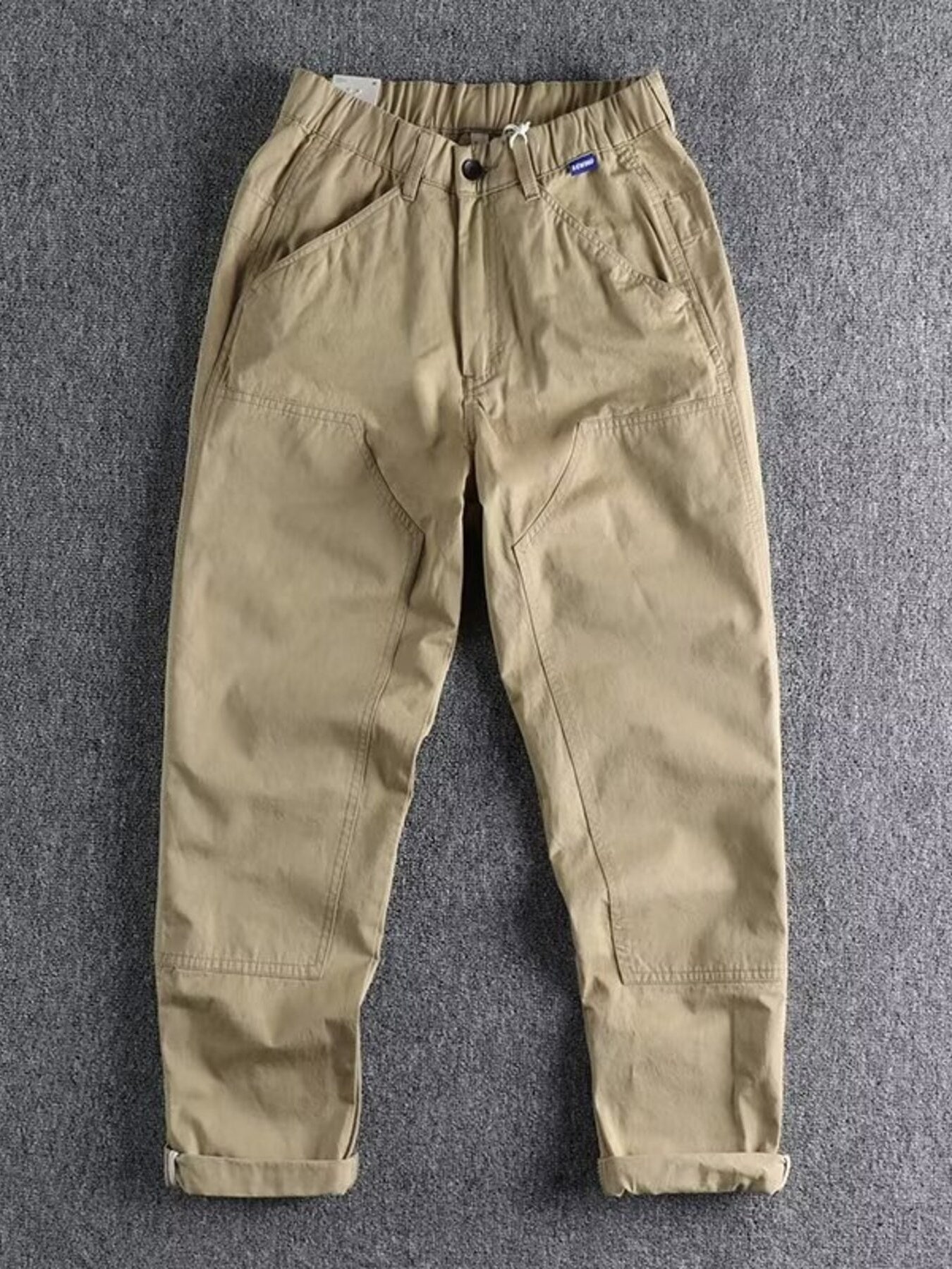 Men's plus size casual cargo pants with elastic waistband in khaki, from Trendsi, featuring multiple pockets and relaxed fit.