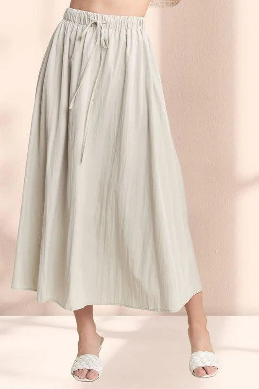 Khaki ADORA drawstring waist crinkle maxi skirt from Trendsi, flowing fabric with a relaxed, bohemian style.