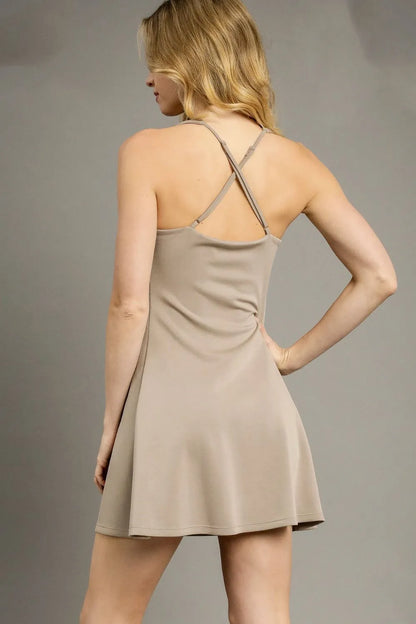Khaki Umgee crisscross square neck active dress with sleeveless design, fitted bodice, and flared skirt, perfect for casual wear.