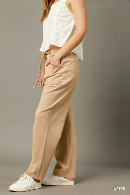 Light-colored Umgee cargo-inspired drawstring pants with a relaxed fit, featuring multiple pockets and a comfortable waistband.