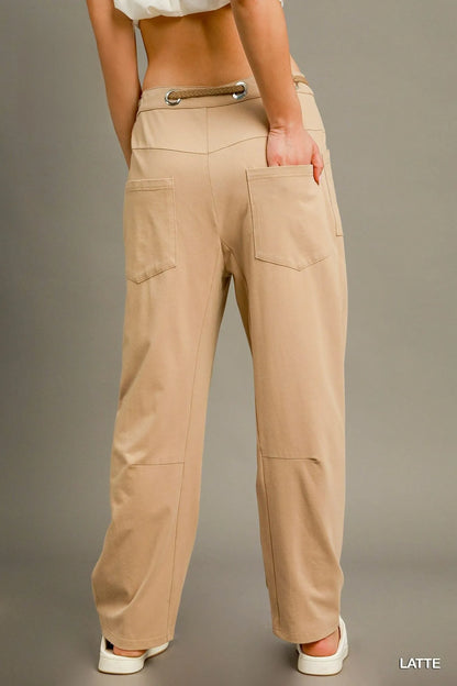Light beige Umgee cargo-inspired drawstring pants with pockets and relaxed fit, styled on a model.