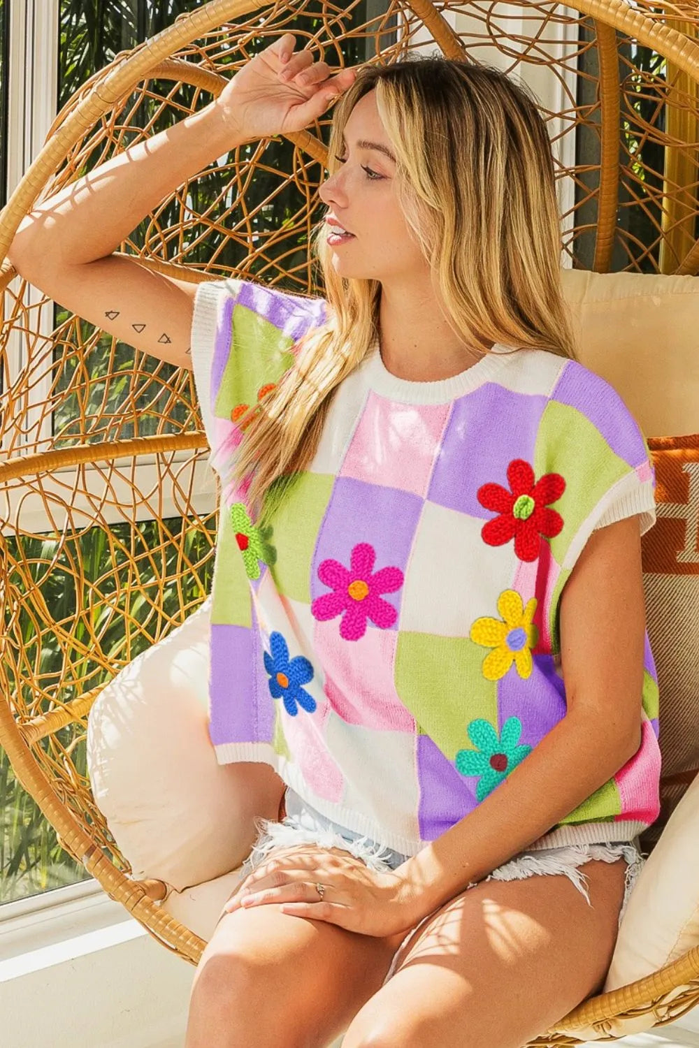 Lavender blush checkered sweater vest with floral patches from Trendsi, featuring a cozy knit and vibrant flower embroidery.