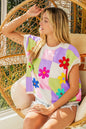 Lavender blush checkered sweater vest with floral patches from Trendsi, featuring a cozy knit and vibrant flower embroidery.