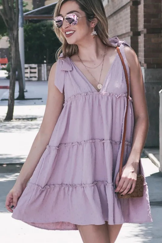 Lavender polka dot layered flounce ruffle dress by Trendsi featuring textured fabric and feminine design.