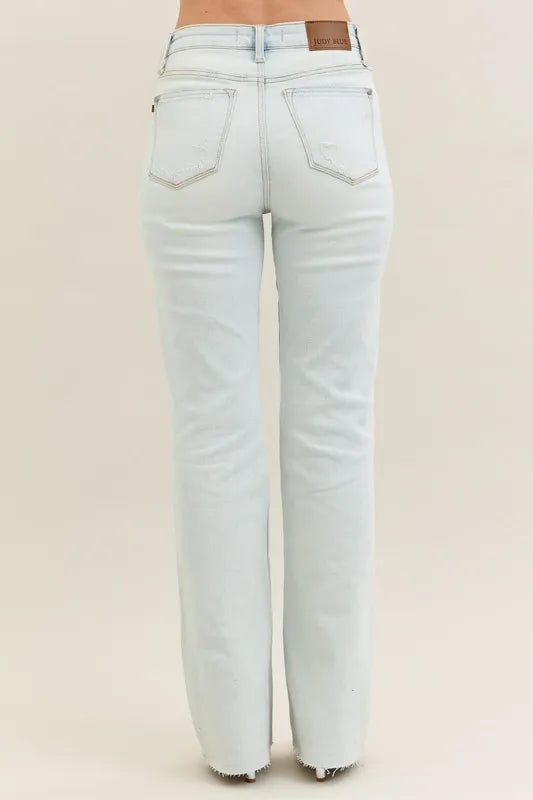 Plus size Judy Blue destroy and fray hem bootcut jeans with distressed details, shown on a model in a natural pose.