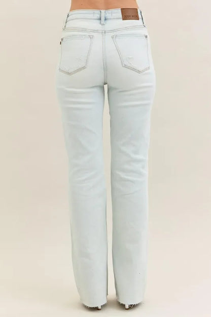 Plus size Judy Blue destroy and fray hem bootcut jeans with distressed details, shown on a model in a natural pose.