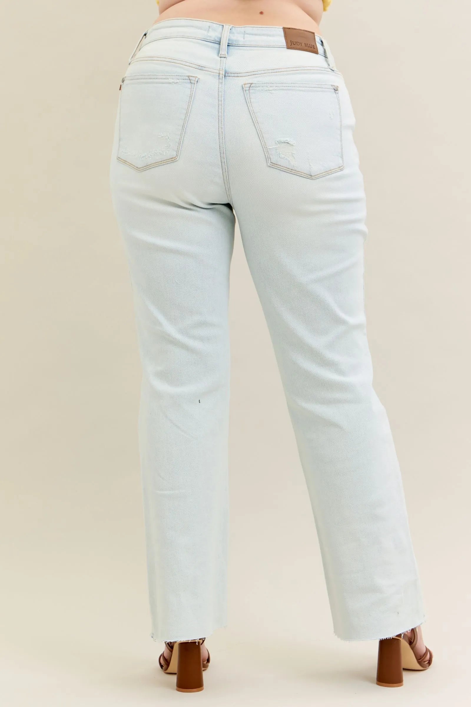 Plus size Judy Blue destroy and fray hem bootcut jeans with distressed details and classic fit, shown in light wash.