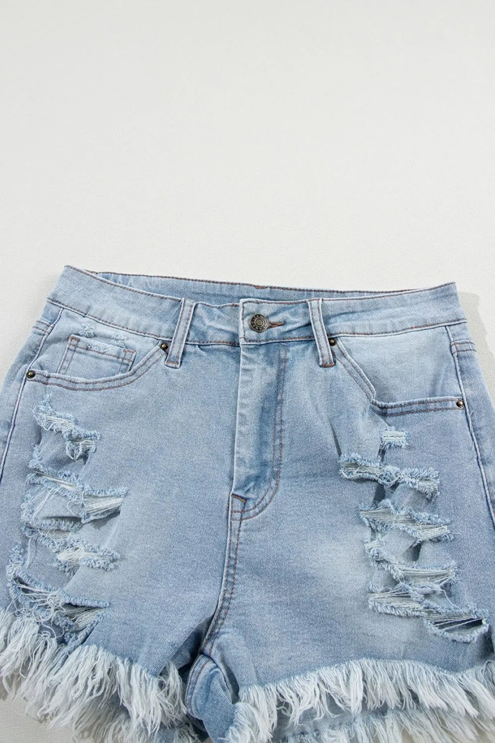 Light blue distressed raw hem high waist denim shorts by Trendsi, featuring a trendy cut and casual style.