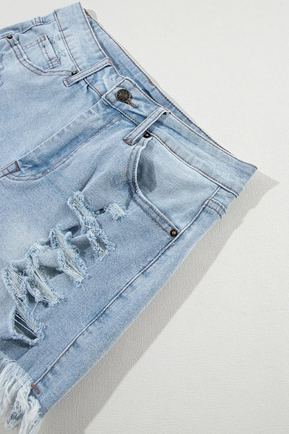 Light blue distressed raw hem high waist denim shorts from Trendsi featuring a casual fit and trendy distressed details.