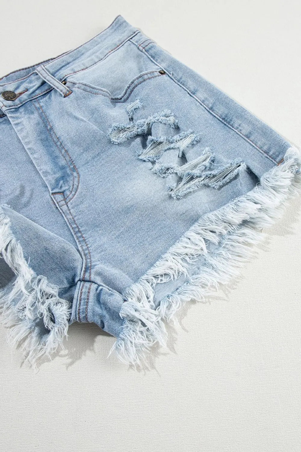 Light blue distressed raw hem high waist denim shorts by Trendsi, showing fit and frayed hem details.