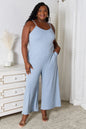 Light blue Trendsi Basic Bae full-size spaghetti strap V-neck jumpsuit laid flat for display.