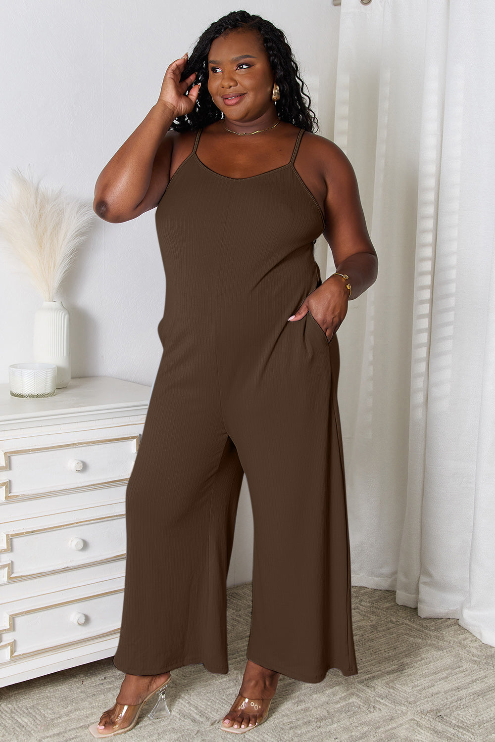 Light blue Basic Bae full-size spaghetti strap V-neck jumpsuit from Trendsi, shown on a model with a relaxed fit and stylish design.