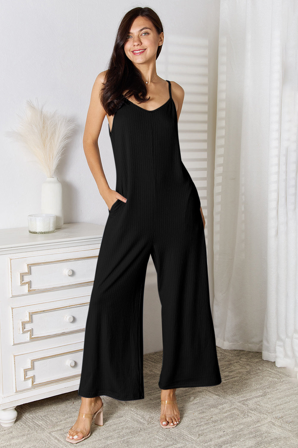 Light blue Basic Bae full-size spaghetti strap V-neck jumpsuit by Trendsi, displayed on a hanger with adjustable straps.